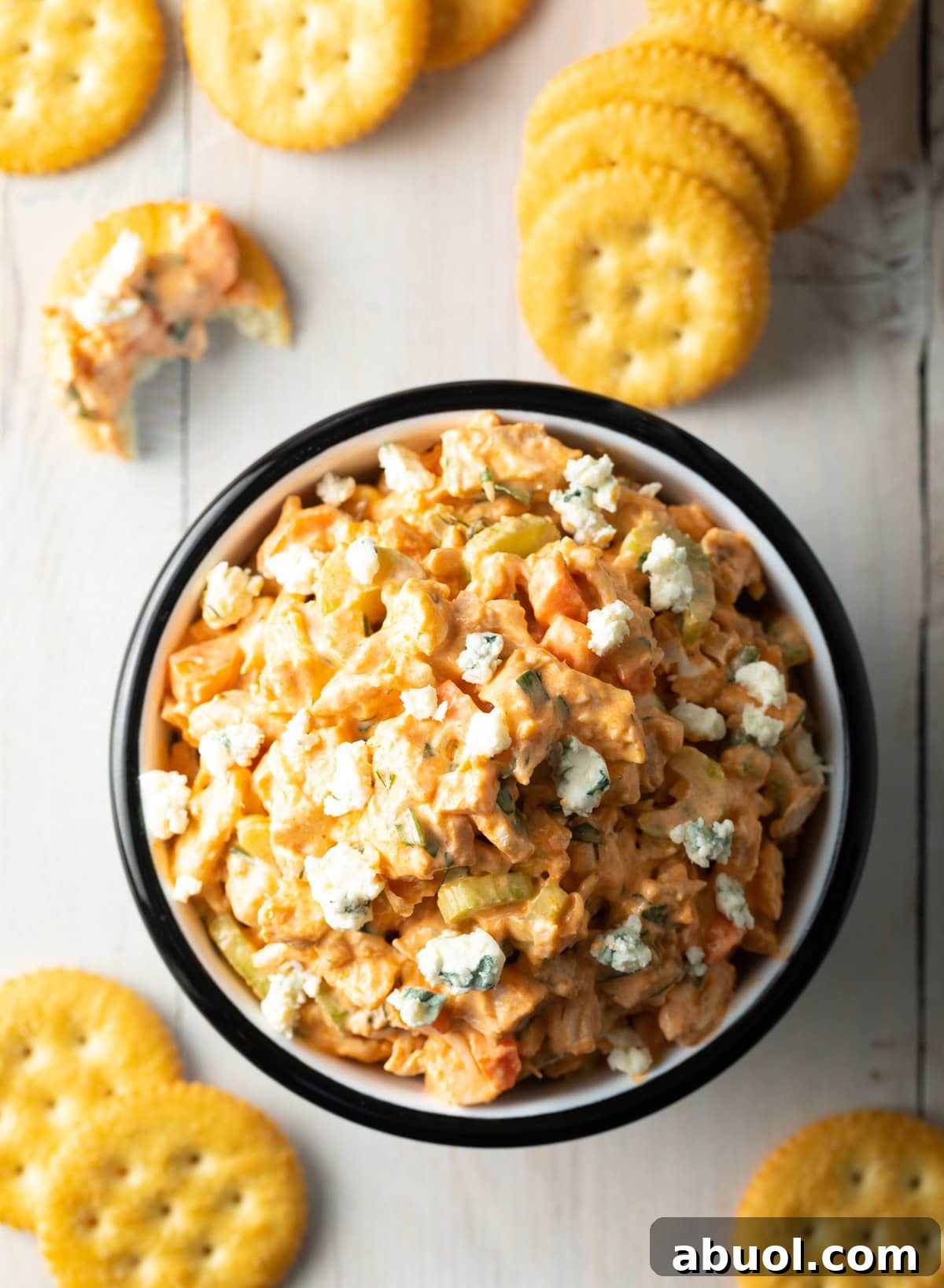 An overhead shot of a bowl of easy buffalo chicken salad, surrounded by crackers.
