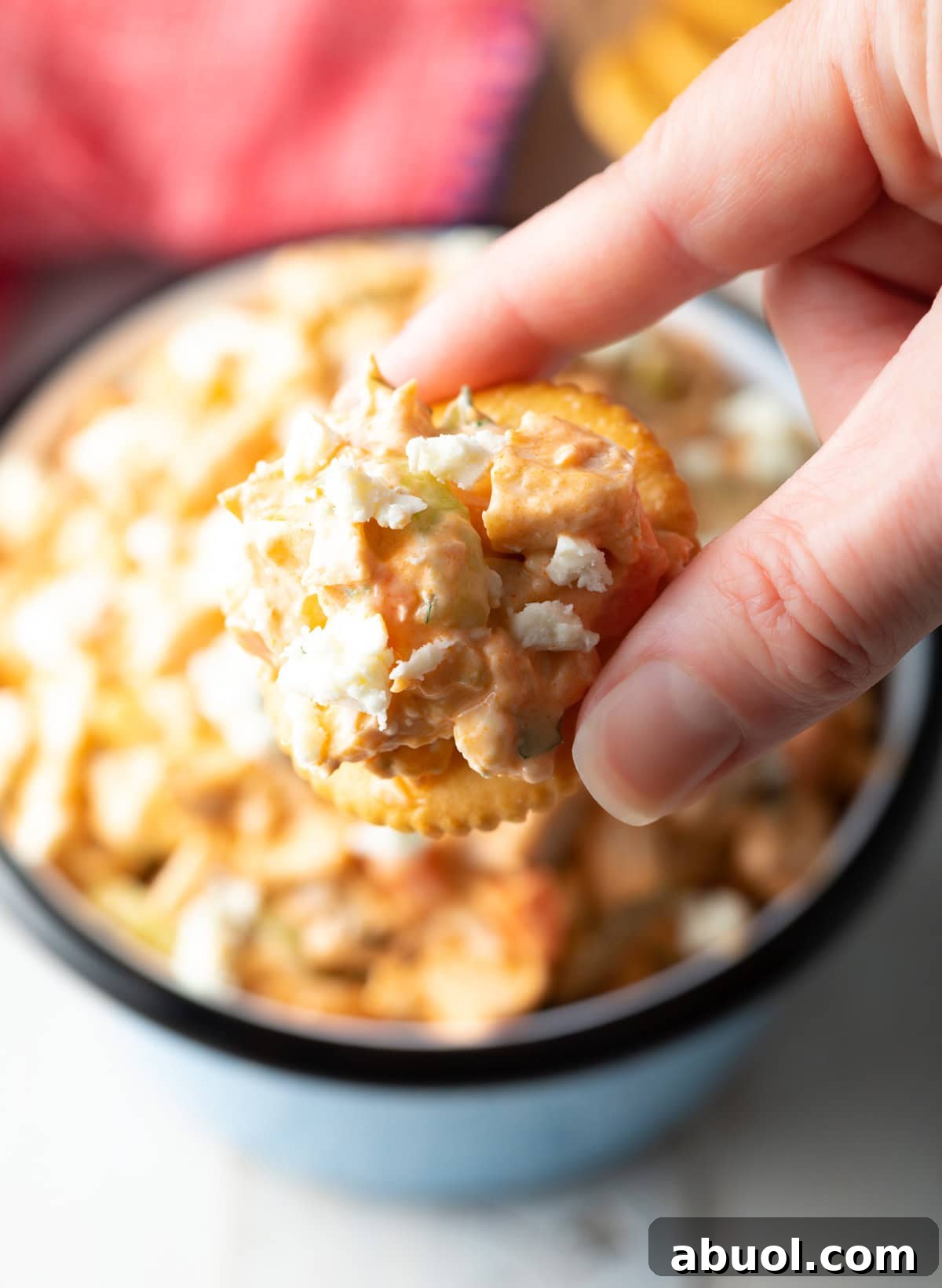 A scoop of a paleo buffalo chicken salad recipe on a cracker.