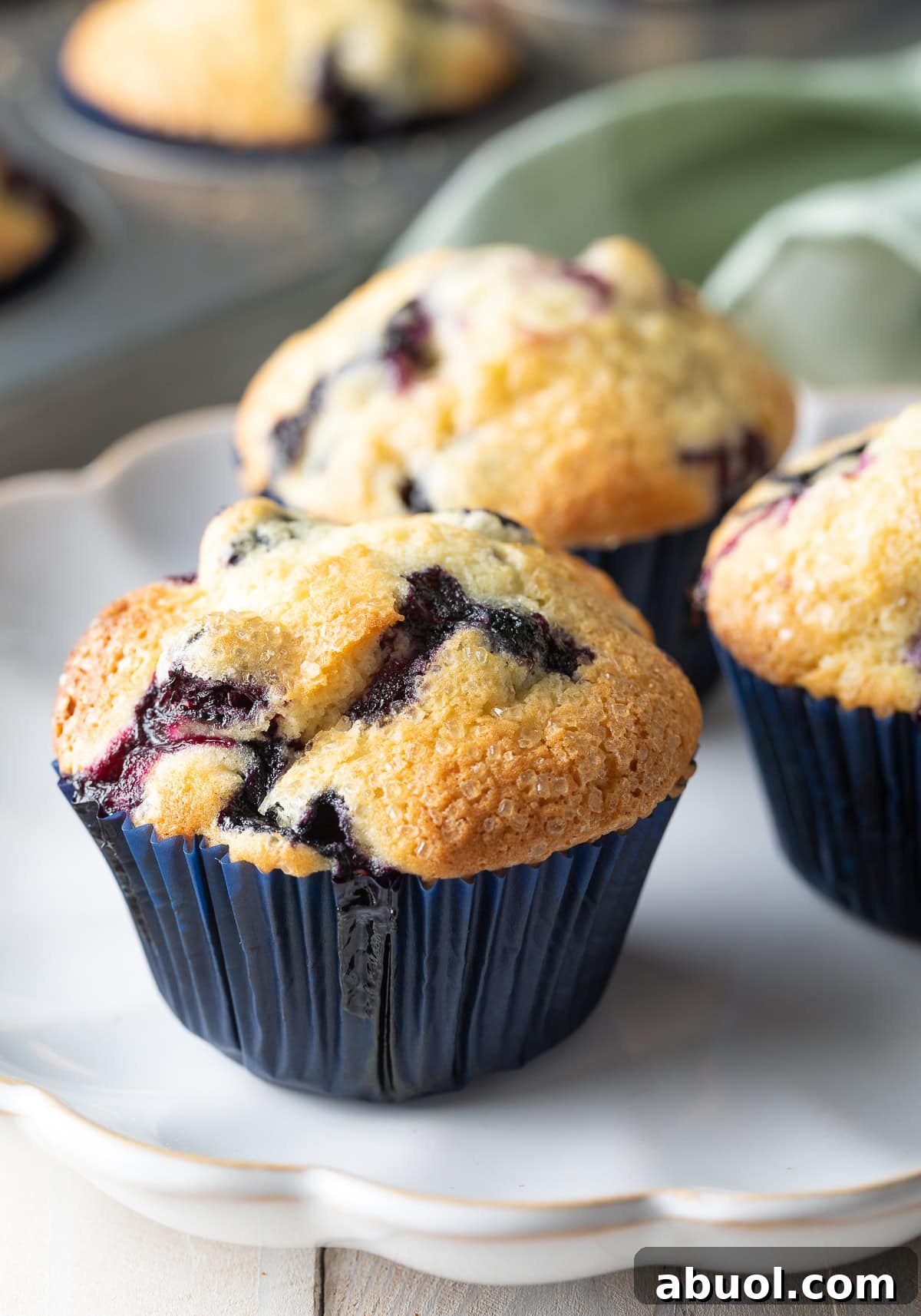 Three easy homemade blueberry muffins on a white plate.