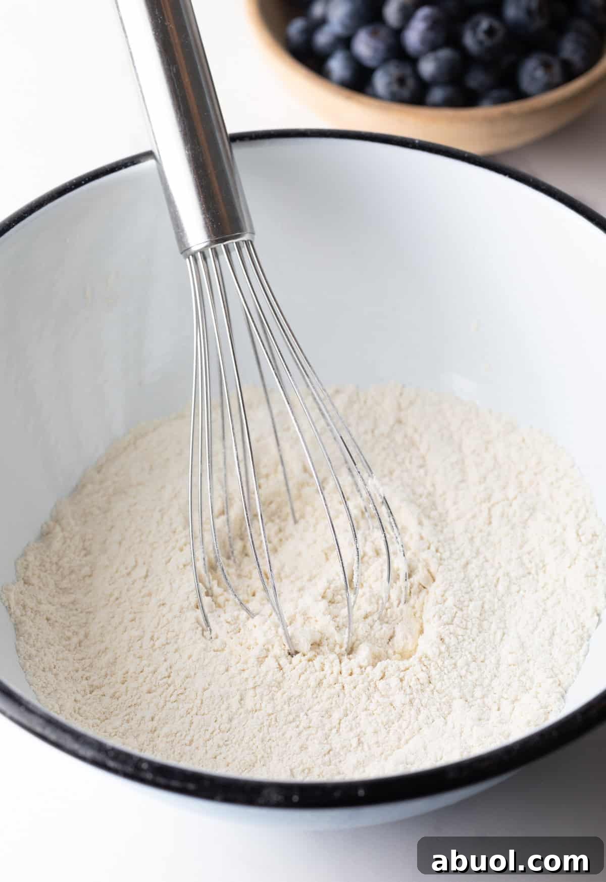 white bowl with dry ingredients and a whisk.