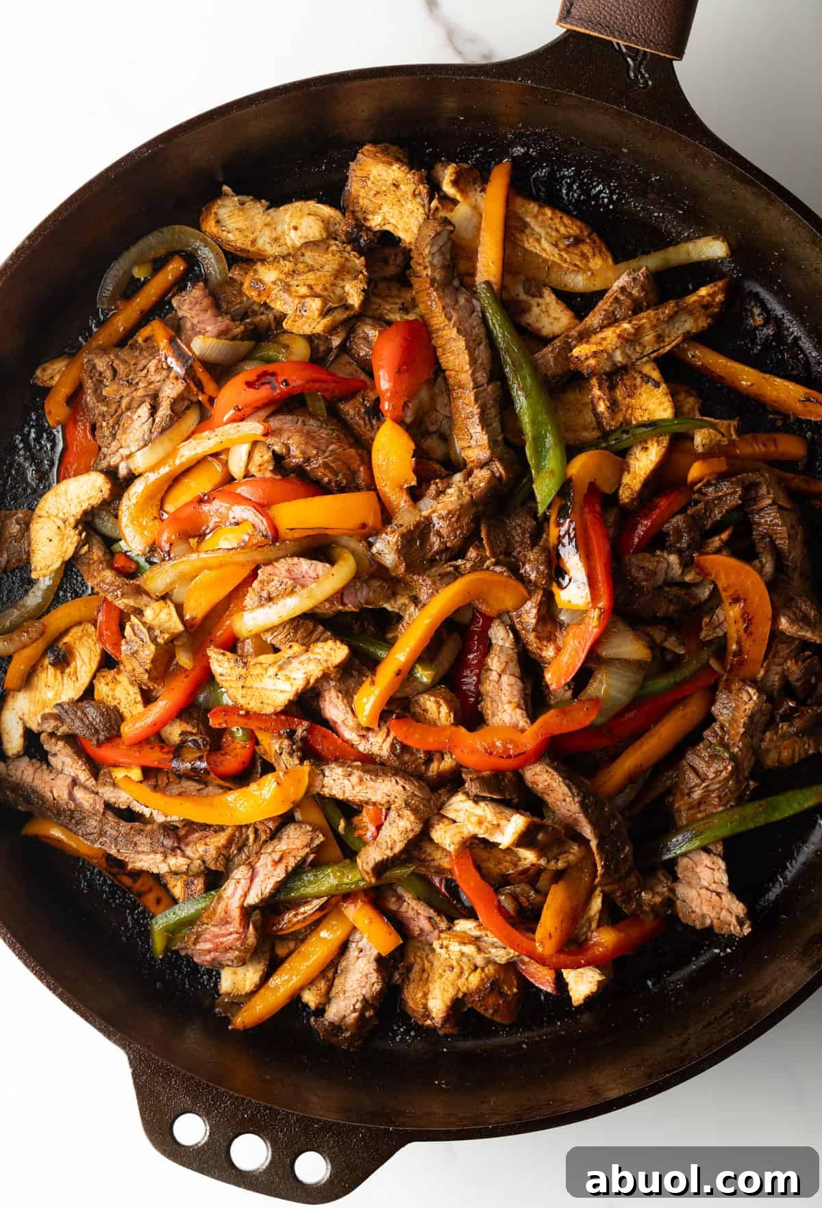An easy steak fajita recipe in a black skillet, with a homemade fajita marinade.