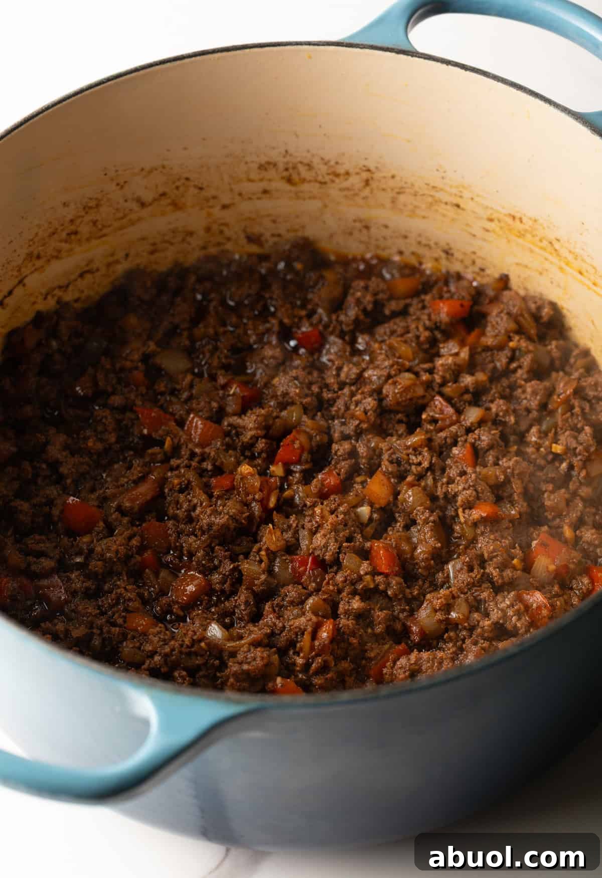 A beef mixture is browning in a pot for a Cincinnati chili recipe.