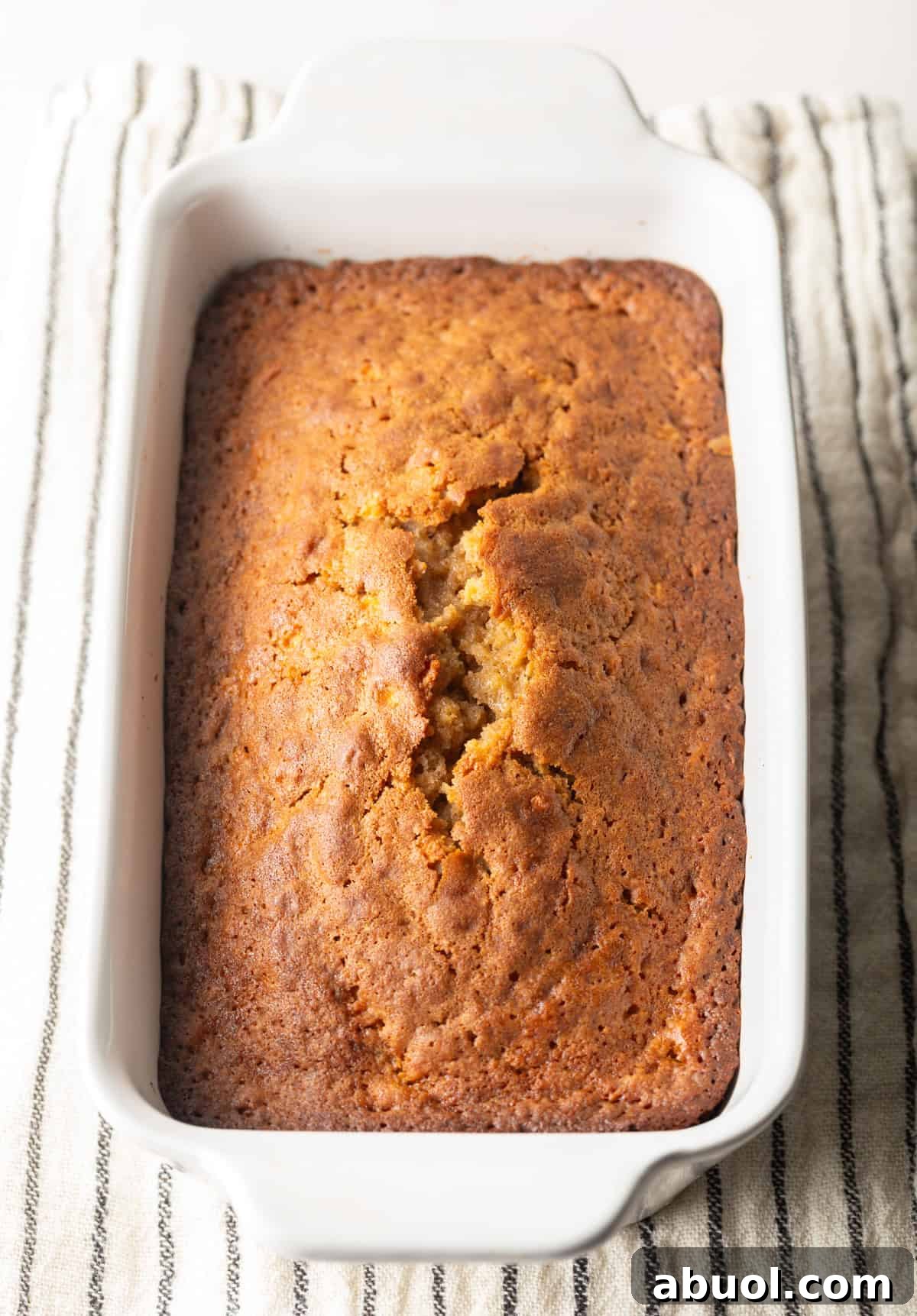 Freshly baked apple bread in a white baking dish.